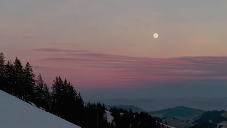 Spektakuläre-Drohnenaufnahmen-Zeigen-Die-Ruhige-Atmosphäre-Des-Sonnenaufgangs-über-Der-Silhouette-Einer-Schneebedeckten-Bergkette