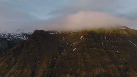 Aerial-panoramic-landscape-view-over-icelandic-mountain-peaks,-on-a-moody-evening