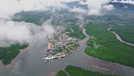 Fishing-Village-Revealed-Through-the-Clouds-Using-an-Aerial-Drone-Over-Lang-Thung-Nang-Dam-River-and-Mangroves-at-Khura-Buri-District-Province,-Thailand