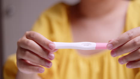 Detail-of-woman-analyzing-pregnancy-test-result