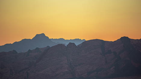 Glowing-orange-sky-at-dusk-above-jagged-sharp-rock-cliffs-in-Egypt