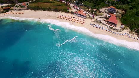 Petani-beach-with-turquoise-waters-and-sunbathers-in-kefalonia,-greece,-in-summer,-aerial-view