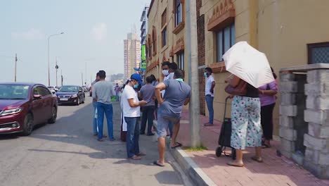 POV-Beim-Vorbeigehen-An-Schlange-Stehenden-Leuten-Und-Beim-Einhalten-Der-Sozialen-Distanz-In-Colombo,-Sri-Lanka