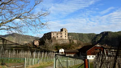 A-helicopter-is-passing-over-the-ruins-of-Rafenstein-Castle-located-above-Bolzano,-South-Tyrol,-Italy