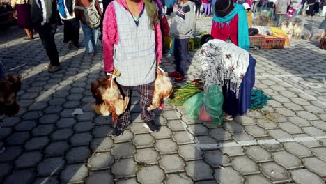 Bright-market-day-in-Otavalo,-Ecuador-with-locals-in-traditional-dress-and-goods-for-sale