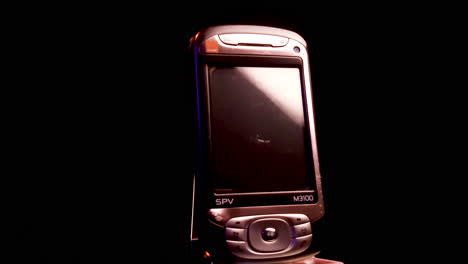 Orangefarbenes-SPV-M3100-Smartphone-Aus-Den-2000er-Jahren-Mit-Rotierendem-Display,-Schwarzer-Hintergrund