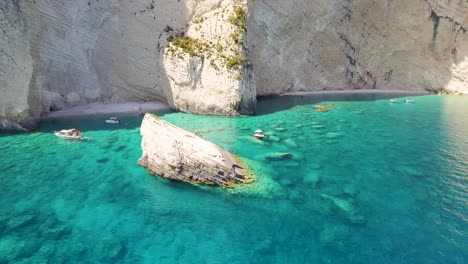 Crystal-clear-turquoise-waters-with-a-large-rock-formation,-Oasi-Beach-near-Keri-Caves,-Zakynthos