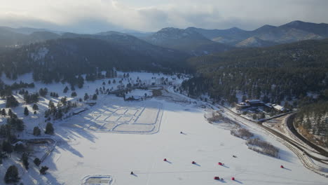 Puesta-De-Sol-Patinaje-Sobre-Hielo-Patinar-Pista-De-Hockey-Lago-Estanque-Hockey-Invierno-Etown-Casa-Del-Lago-De-Hoja-Perenne-Pesca-Tiendas-De-Campaña-Denver-Campo-De-Golf-Colorado-Aéreo-Cinematográfico-Zumbido-Hora-Dorada-Invierno-Nieve-Tráfico-Lento-Hacia-Atrás