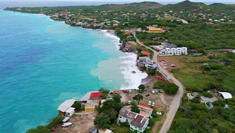 Panoramic-aerial-overview-of-Westpunt-Curacao-as-strong-ocean-waves-stir-sand-up-in-water
