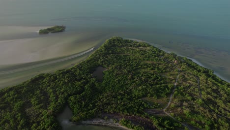 Beautiful-Aerial-Establishing-Shot-of-Large-Picturesque-Island,-Boat-Crossing-Frame