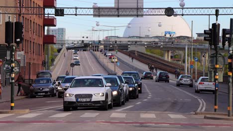 Bike-and-car-traffic-in-foreground-of-Globe-Arena-in-Stockholm,-Sweden