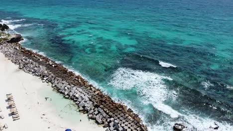 Waves-breaking-on-breakwater-of-Cancun-tropical-sandy-beach,-Mexico