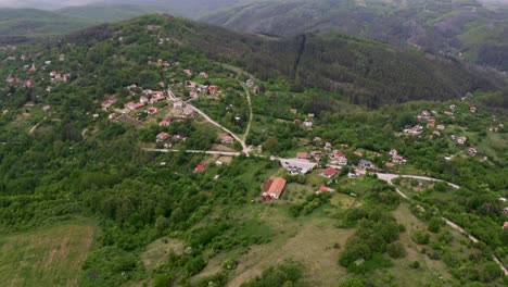 Drone-panning-from-the-left-to-the-right-side-of-the-frame,-capturing-the-landscape-of-Tsarichina-Hole-Village-in-a-remote-area-in-Bulgaria