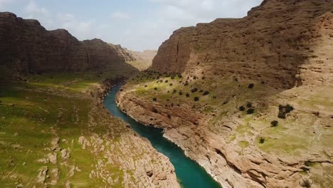 Schönes-Tal-Umgeben-Von-Hohen-Bergen-Im-Frühling,-Grüne-Naturlandschaft-Auf-Dem-Land-Im-Iran,-Die-Felsklippe,-Schlamm,-Lehm,-Abgrund,-Brauner-Geologischer-Flussfluss,-Erosion-Im-Hintergrund