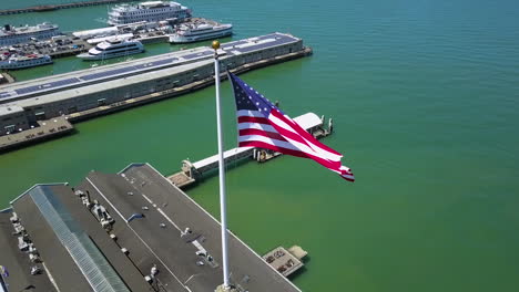 Vista-Aérea-Lejos-De-Una-Bandera-Estadounidense-En-La-Torre-Del-Edificio-Del-Ferry,-En-Embarcadero,-San-Francisco.