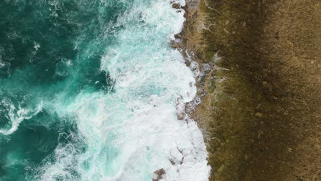 Descripción-Estática-De-Arriba-Hacia-Abajo-Del-Agua-Verde-Del-Océano-Y-La-Cal-Chocando-Contra-Rocas-Afiladas-Y-Dentadas