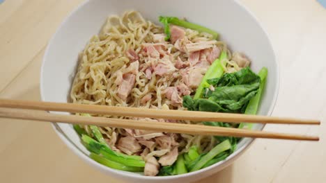 Chopsticks-On-A-Bowl-Of-Bakmi-Wheat-Noodles-Served-With-Bok-Choy-And-Meat