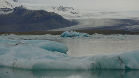 Glacier-Lagoon,-Jökulsárlón,-Iceland,-with-icebergs-and-flowing-icy-blue-water