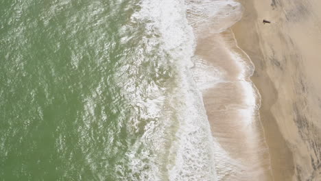 Aerial-view-of-the-sea-and-the-waves-at-Cumbuco-beach,-Ceara,-Brazil
