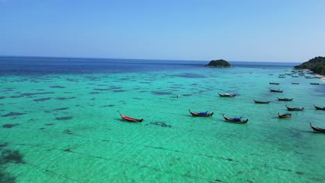 longtail-boat-beach-rocky-cliff-island-turquoise-blue-sea