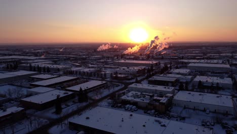 Drone-shot-of-a-steaming-factory-during-sunset