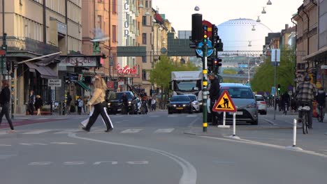 Motorcycle-among-traffic-on-Stockholm-street,-Globe-Arena-in-background