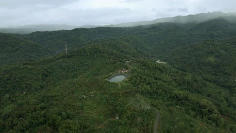 Aerial-view-of-endless-hill-forest-with-water-pond-for-reservoir