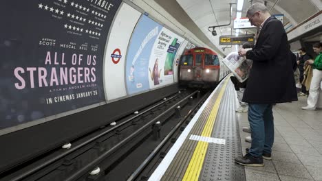 Passagiere-Beobachten-Die-Ankunft-Eines-Zuges-Der-Bakerloo-Line-Am-Bahnsteig-Der-Oxford-Street-Station-In-London,-England,-Und-Veranschaulichen-So-Das-Konzept-Der-Erreichbarkeit-Des-Städtischen-Nahverkehrs-Und-Der-Pendleranbindung.