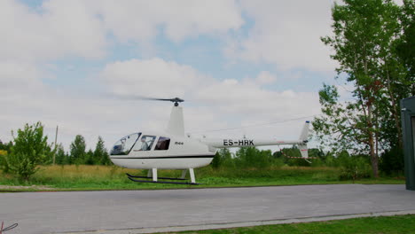 Robinson-R44-Helicopter-take-off-and-fly's-away-over-a-field