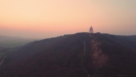 Luftaufnahme-Eines-Hindutempels-Auf-Einem-Hügel-Mit-Treppen,-Die-Während-Des-Sonnenuntergangs-In-Einem-Dorf-In-Gwalior-In-Madhya-Pradesh,-Indien,-Dorthin-Führen