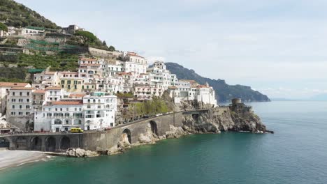 Amalfi-coast-with-boats-and-mediterranean-architecture-on-a-sunny-day,-cliffside-ocean-view,-aerial-view