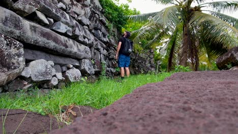 Tourist-walking-around-the-outer-walls-of-the-ancient-city-of-Nan-Madol-on-the-tropical-island-of-Pohnpei,-Federated-States-of-Micronesia