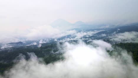 Luftaufnahmen-über-Einem-Lebendigen-Regenwald-Mit-Einem-Aktiven-Vulkan-Im-Hintergrund,-Die-Die-Bemühungen-Um-Den-Naturschutz-Hervorheben,-Luftaufnahmen-In-4K-Drohnen