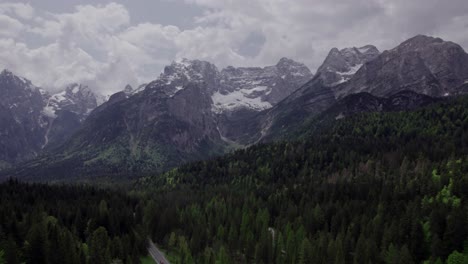 Pinos-Verdes-Aéreos-Con-Picos-Nevados-Y-Rocosos,-Dolomitas