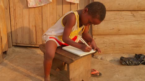 Young-back-girl-doing-school-work-on-a-bench-at-a-makeshift-school