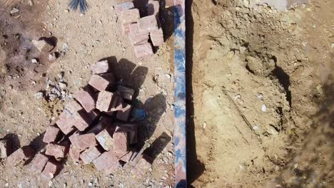 Construction-using-earthen-blocks,-Building-the-foundation-of-the-house,-Workers-work-at-a-construction-site-in-India,-Building-a-house-with-red-stone-,-Works-using-cement-