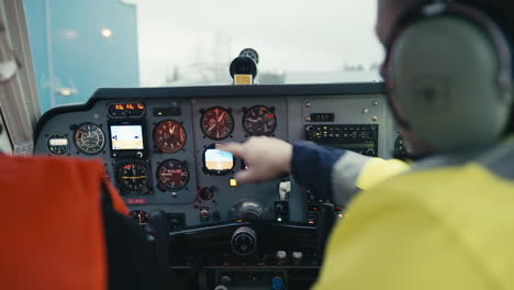 Flight-instructor-showing-cockpit-instruments-to-pilot-student-in-small-single-engine-Beechcraft-airplane