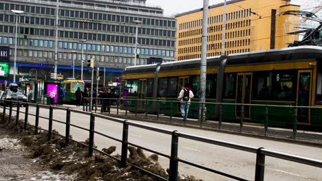 Tram-in-Helsinki-city-center-during-daytime,-busy-street-scene-with-pedestrians