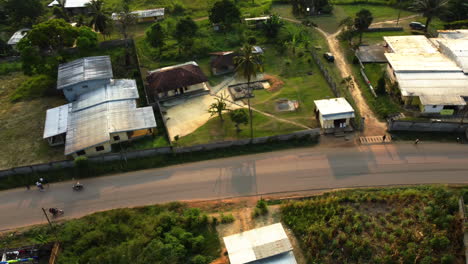 Aerial-view-tracking-mopeds-on-the-streets-of-Ebolowa,-sunset-in-south-Cameroon