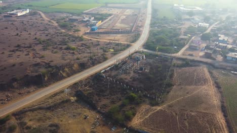 Aerial-drone-shot-of-a-small-capacity-electricity-plant-along-a-village-road-in-Madhya-Pradesh-India
