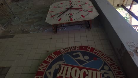 Antiguo-Cronómetro-Analógico-Y-Logotipo-Del-Club-De-Natación-Del-Equipo-De-La-Planta-De-Energía-Nuclear-De-Chernobyl-Junto-A-Una-Piscina-Abandonada-En-Pripyat,-Ucrania