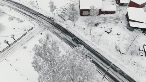 Drohnenaufnahmen-Von-Einem-Auto,-Das-Auf-Einer-Winterlichen-Waldstraße-Fährt