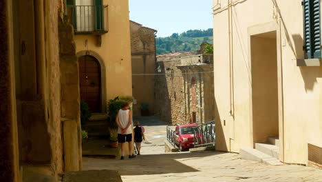 Ein-Paar-Leute-Schlendern-Die-Straße-In-Monte-San-Savino-Entlang,-Einer-Wunderschönen-Kleinen-Toskanischen-Stadt,-In-Der-Das-Food-Festival-Sagra-Della-Porchetta-Stattfindet