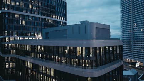 Aerial-drone-view-of-modern-office-business-building-with-big-windows-at-night