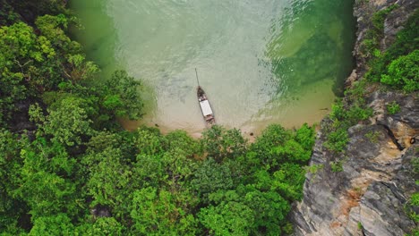 Un-Dron-Aéreo-Ascendente-Revela-Un-Barco-De-Cola-Larga-En-Medio-De-Impresionantes-Aguas-Turquesas-Y-Acantilados-De-Piedra-Caliza-En-Blue&#39;s-Hong,-Ko-Roi,-Tailandia