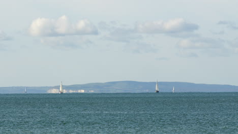 Extrabreite-Aufnahme-Des-Solent-Mit-Der-Isle-Of-Wight-Im-Hintergrund-Und-Entfernten-Segelbooten,-Aufgenommen-In-Milford-On-Sea