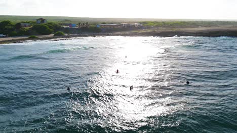 Ocean-waves-break-as-surfers-wait-at-Playa-Kanoa-curacao-at-sunset