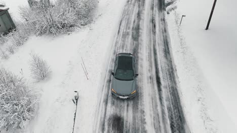 Drone-footage-of-car-driving-in-the-winter-forest-road