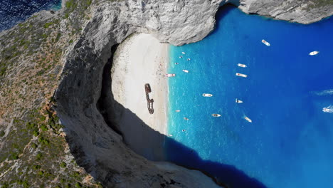 Aérea:-Vista-De-Arriba-Hacia-Abajo-De-La-Playa-De-Navagio-En-La-Isla-De-Zakynthos,-Grecia-Durante-El-Verano