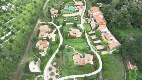 Tilt-Down-Aerial-Shot-of-La-Toscana-Resort-with-Italian-Gardens-and-Villas-from-Above,-Ratchaburi,-Thailand
